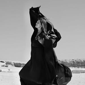 Lady dances in the desert with scarf in a black and white photograph